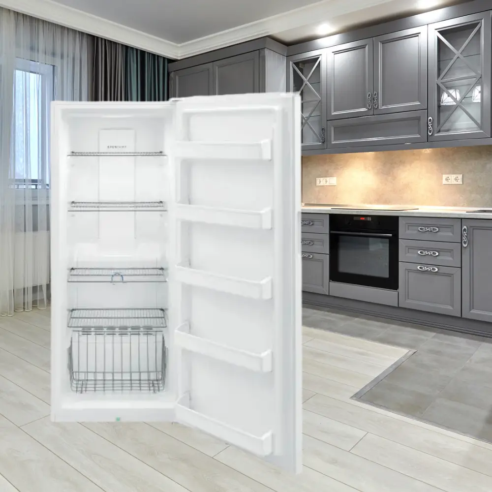 A refrigerator in the middle of a room with grey cabinets.