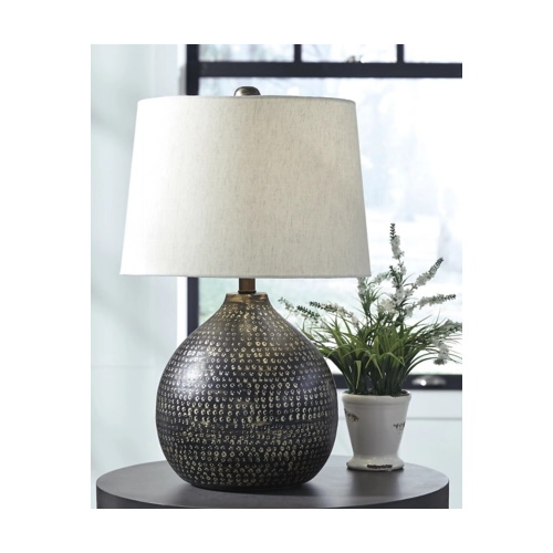 A lampshade on an end table with a plant