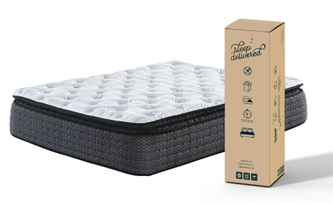 A box sitting next to a mattress with white sheets.