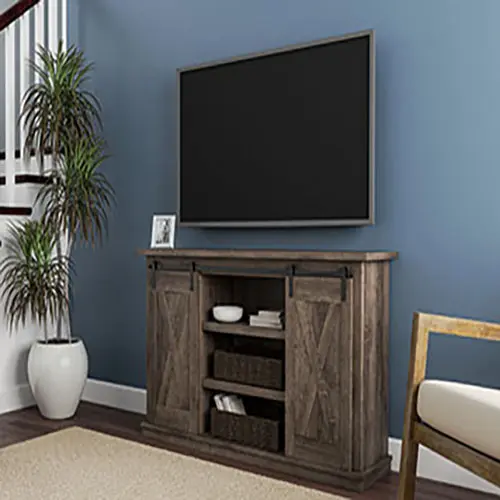 A tv stand with sliding doors and a shelf.