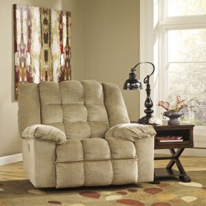 A beige recliner sitting in front of a window.
