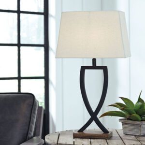 A table lamp on top of a wooden table.