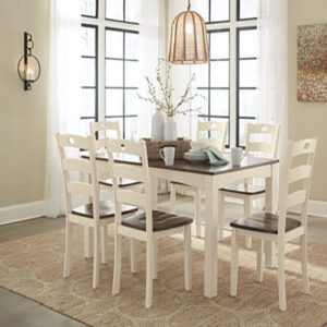 A dining room table with six chairs and a vase.
