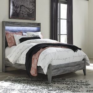 A bed with a gray headboard and white sheets.