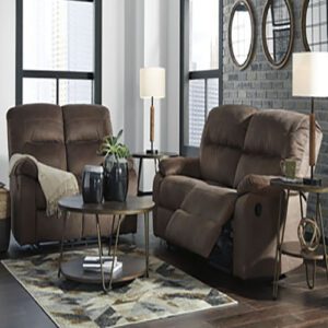 A living room with two brown recliners and a table