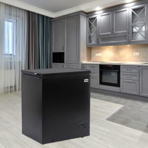 A black refrigerator freezer sitting in the middle of a room.