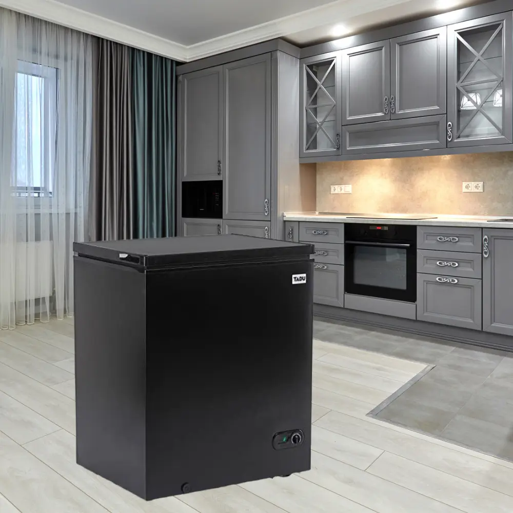 A black refrigerator freezer sitting in the middle of a room.